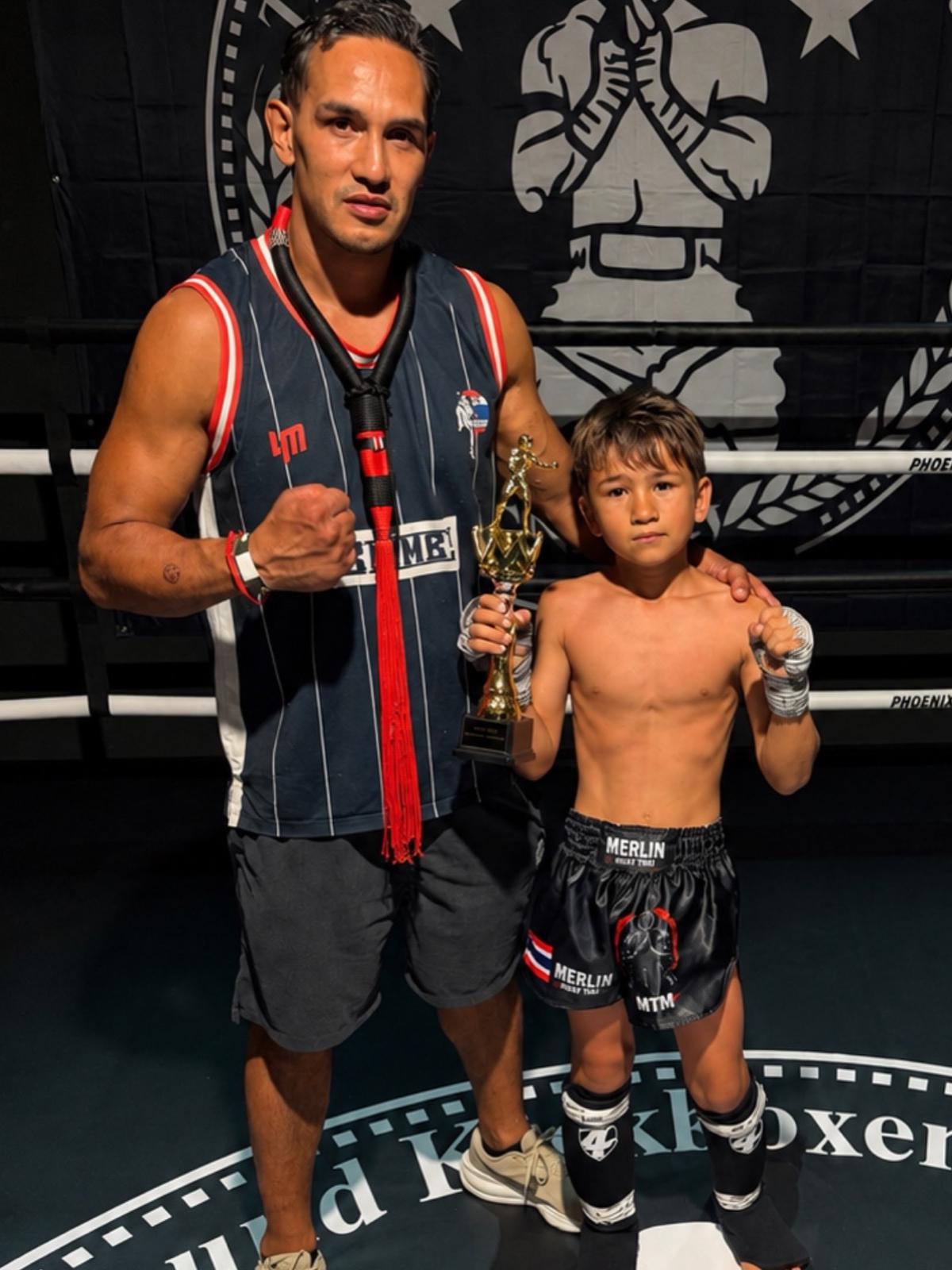 Merlin Fröhner mit seinem Sohn Lio und einem Pokal am Ring